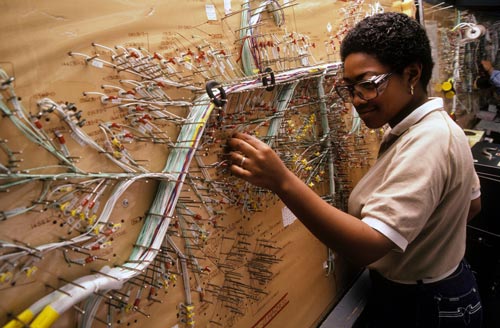 Woman assembling wire harness for aerospace